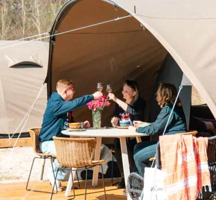 vrienden proosten in de zon op het terras van de dune tent deluxe