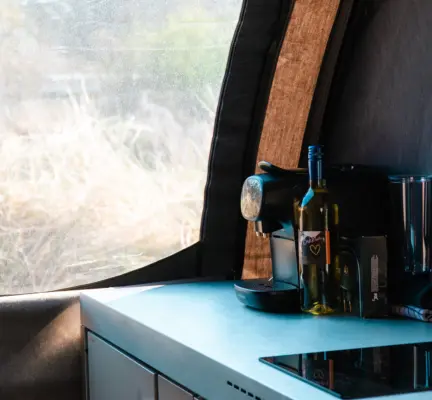 in de dune tent deluxe zit een kitchenette met elektrisch kookstel en koffiezetapparaat en waterkoker