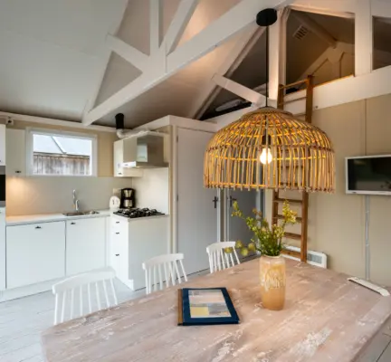 Strandhuisje is gezellig ingericht met een eettafel en bank en stoelen en veel licht