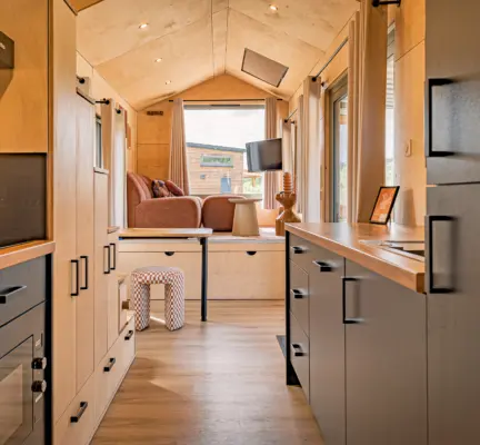 interieur tiny timber luxe keuken met vaatwasser en zitgedeelte met bank en tv